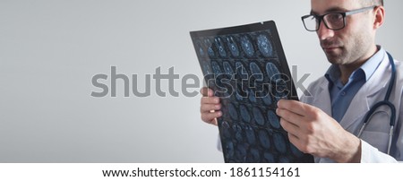 Doctor looking at xray picture of head.