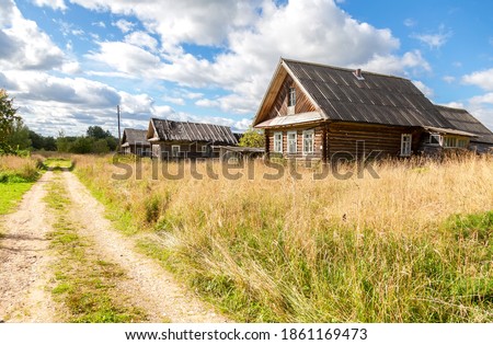 Old rural wooden houses in abandoned russian village in summer sunny day. Novgorod region, Russia Royalty-Free Stock Photo #1861169473