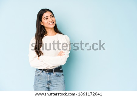 Young indian woman isolated on blue background smiling confident with crossed arms. Royalty-Free Stock Photo #1861172041