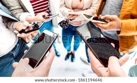 Closeup of people using mobile smart devices - Detail of hands sharing photos on social media network with smartphone - Technology concept and cellphone culture with selective focus on right phone