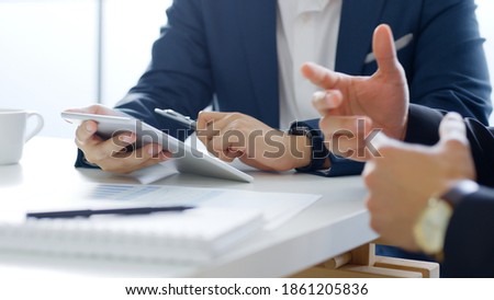 Professional businessman in suit using tablet meeting about business finance, working in office