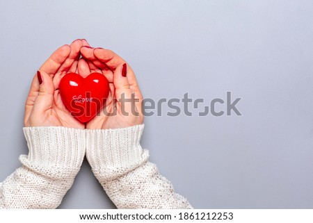 Female open hands holding red heart on gray background Happy Valentine's day, Mother's day, Heart health care, hope, donation, creative, self care concept Top view Flat lay Place for text Holiday card Royalty-Free Stock Photo #1861212253