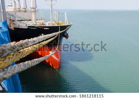 Close-Up Of Rope Tied To Boat Moored At Harbor with light and shadow on sea water in shipyard under maintenance Thailand.