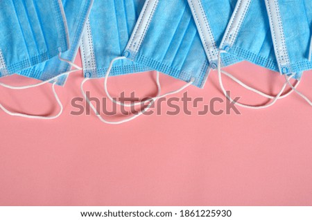 Blue face masks on pink background, protective medical equipment, copy space