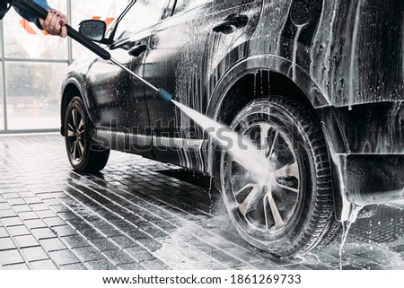 Woman washing her car in a self-service car wash station.Car wash self-service.  Royalty-Free Stock Photo #1861269733