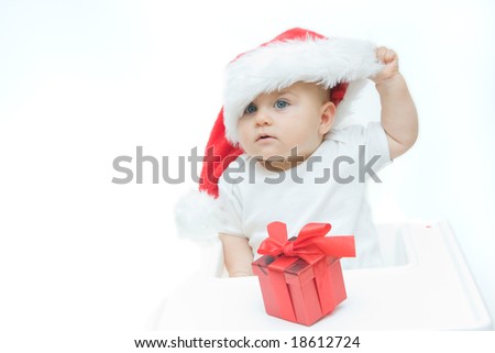 little, cute baby boy wearing Christmas hat, on white