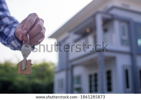 Homeowner holding a new house key from a broker after agreeing to buy a mortgage-home investment. Concept buying a house , a new home. Royalty-Free Stock Photo #1861285873