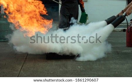 Man teaches or training how to use carbon dioxide (CO2) fire extinguishers to extinguish fires from fuel in house or industry for safety. Royalty-Free Stock Photo #1861290607