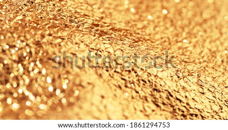 Gold crumpled glittering background. Shiny yellow surface. Shallow depth of light. Event image cover.