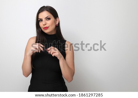 Beautiful girl putting on makeup on white background.