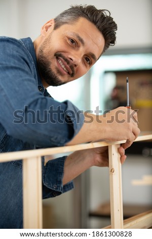man assambles a wooden furniture