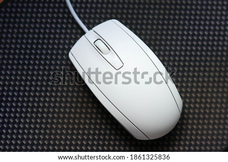 white wired mouse for a computer on a dark background
