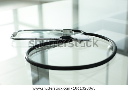 Stethoscope lies on a glass table in an office space