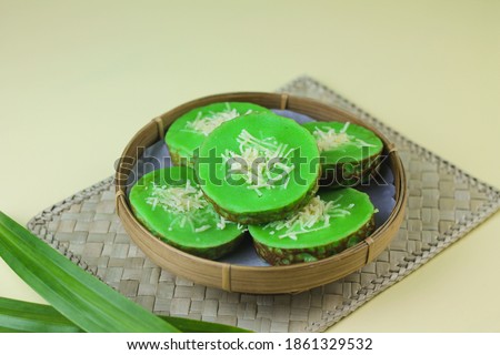 Potato Mud Cake or Kue Lumpur Kentang Pandan, Indonesian traditional cake made from potato, flour, eggs and pandanus leaves. Served on bamboo plate topping with grated cheese. 