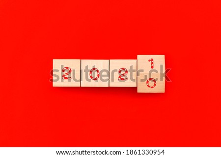 Wooden cubes block to change 2020 to 2021 year on red background. Merry Christmas and happy new year concept.
