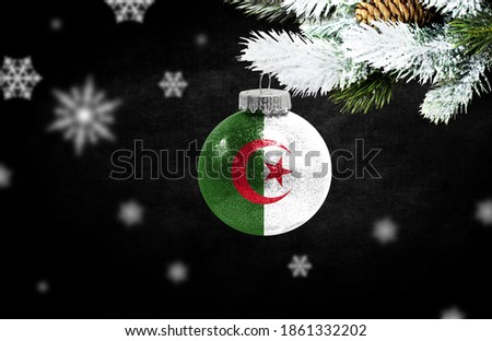 Happy new Year 2021, flag of Algeria on a christmas toy, decorations isolated on dark background. Creative christmas concept.