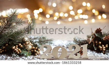 Cozy Christmas background with decorative wooden 2021 numbers on blurred background with lights.