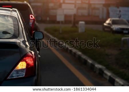Rear side of cars on the road. Stop and open light brake with turn signal light. for U-turn on the asphalt road. Environment and evening light Royalty-Free Stock Photo #1861334044