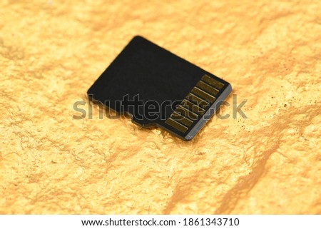 SD memory card isolated on gold background. Soft-focus