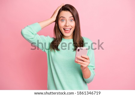 Photo of astonished person arm on head hold phone open mouth turquoise sweater isolated on pink color background