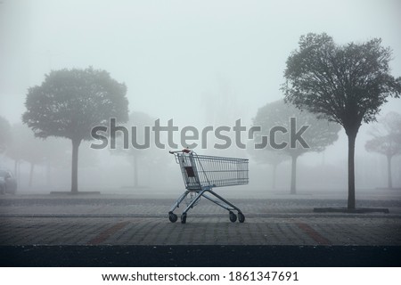 Abandoned shopping cart on parking lot in thick fog. Themes shopping, financial crisis and gloomy weather. Royalty-Free Stock Photo #1861347691