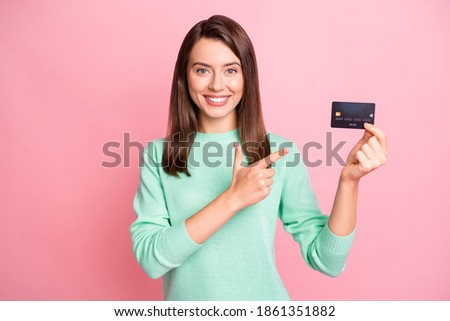 Photo of lady hold credit card direct finger beaming smile wear teal sweater isolated pink color background