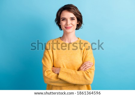 Photo portrait of cute female student with folded hands wearing yellow pullover isolated on vibrant blue color background