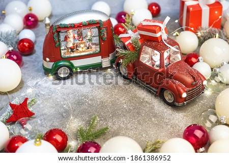 christmas mockup red car with gifts and a trailer trailer with santa claus driving on a gray background with christmas decor snow and lights
