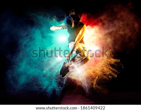 Hip-hop dance party. Young man break dancing on smoke background