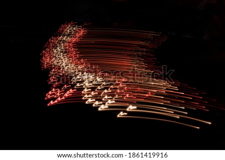A creative, abstract, imaginative image of flag of Latvia made  from many candles in the dark by camera movement. Place for text.