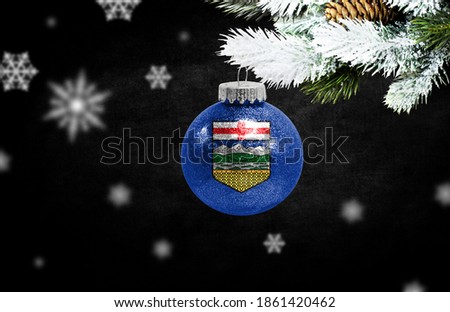 Happy new Year 2021, flag of Alberta on a christmas toy, decorations isolated on dark background. Creative christmas concept.