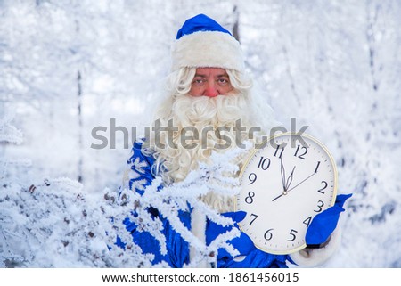 Christmas theme, sales, Happy  Santa Claus in a snowy forest, Santa on the background of a winter forest; Russian Santa(Grandfather Frost), The clock in the hands of Santa shows five minutes to twelve