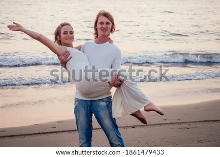 Justmarried couple running on a sandy beach