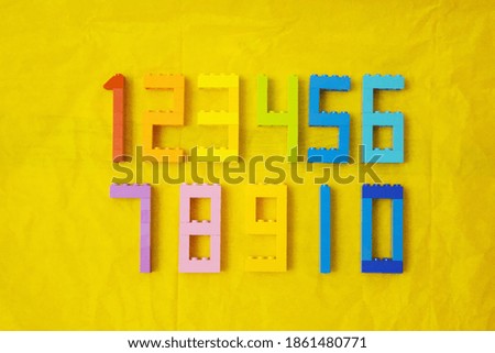 Yellow paper and parts of numbers 2,3,4,5,8,9 on it Numbers background 1-10 Royalty-Free Stock Photo #1861480771