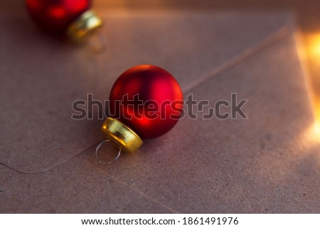 christmas congratulations - paper envelope with bright glass red christmas balls and lights background, happy new year