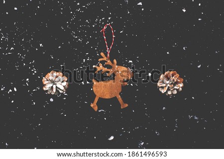 Festive concept with blurred effect. Christmas wooden figurines deer on dark background.