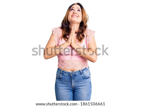 Young beautiful caucasian woman wearing casual clothes begging and praying with hands together with hope expression on face very emotional and worried. begging. 