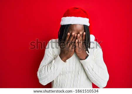 African american man with braids wearing christmas hat rubbing eyes for fatigue and headache, sleepy and tired expression. vision problem 