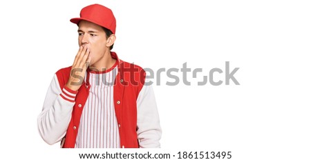 Handsome caucasian man wearing baseball uniform bored yawning tired covering mouth with hand. restless and sleepiness. 