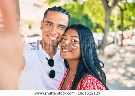 Young latin couple smiling happy making selfie by the camera at street of city.