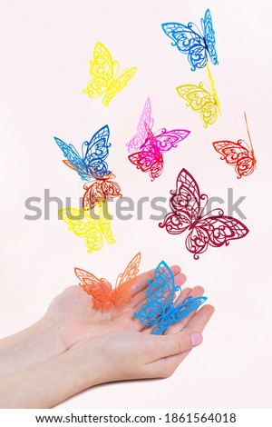 Openwork paper butterflies fly out of girl's hands. Paper art and craft
