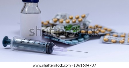 selective focus on injection syringe, bottle and tablets on white background