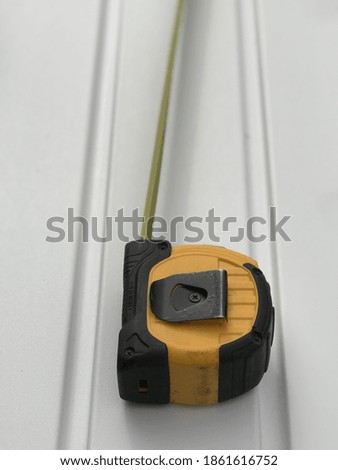 Closeup of a measuring tape on a solid background