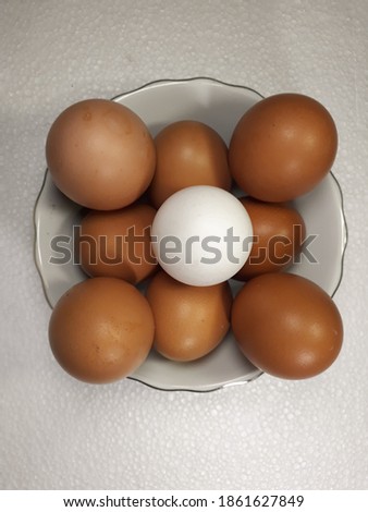 Raw chicken eggs in bowl on white cloth background