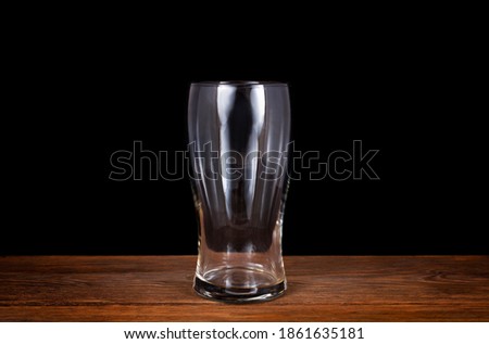 Beer glass on a wooden table isolated on a black background.  