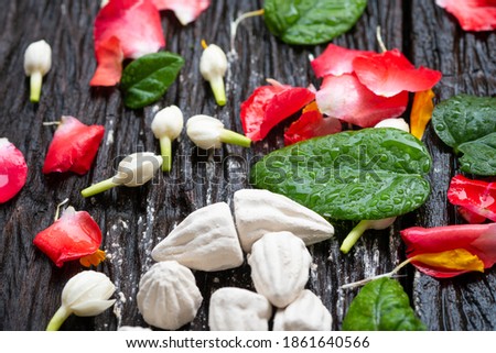 Roses, jasmine, marigolds and chalk powder on old wooden floor, Songkran Festival or Thai New Year.