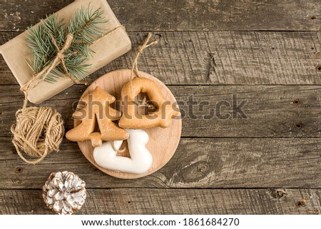 New Year's composition. Gingerbreads, gift wrapped in paper and Christmas decorations on a wooden background. Christmas, winter, new year concept. Flat lay, top view.