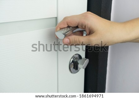 beautiful female hand opens the front door to an apartment or office