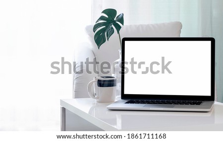 Mockup blank screen laptop on coffee table in living room. Copy space.