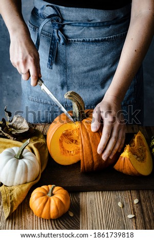 Person cutting Halloween pumpkin closeup